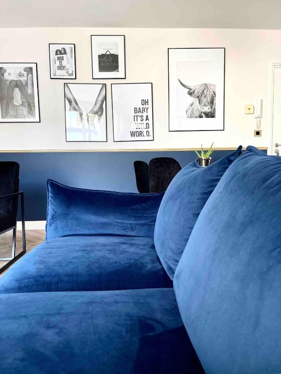 - un lit bleu dans une chambre avec des photos sur le mur dans l'établissement Flanelles - beautiful apartment Lyon 8, à Vénissieux