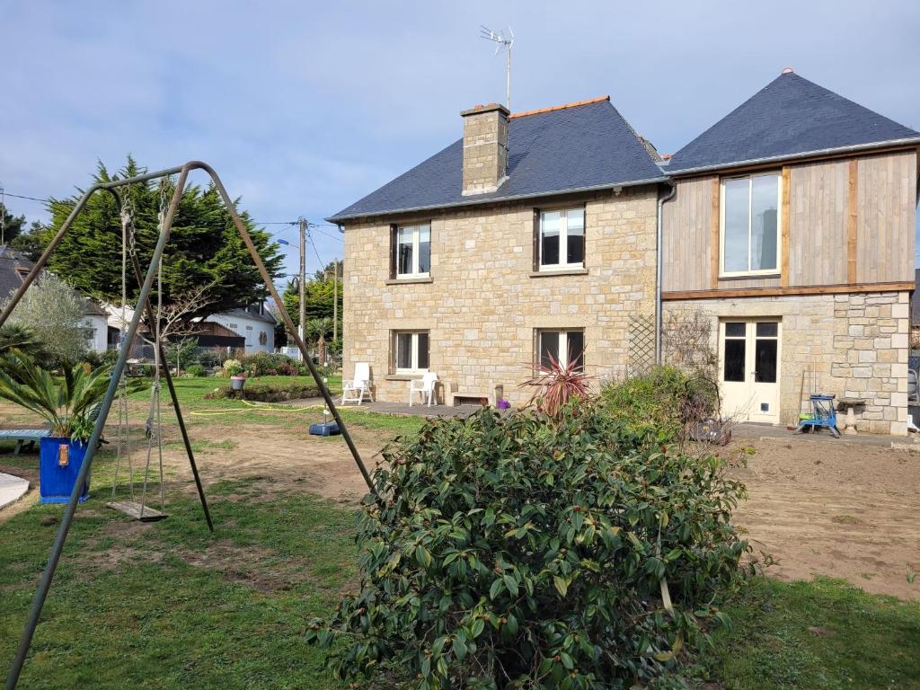 una casa con un parque infantil delante en saint lunaire, en Saint-Lunaire