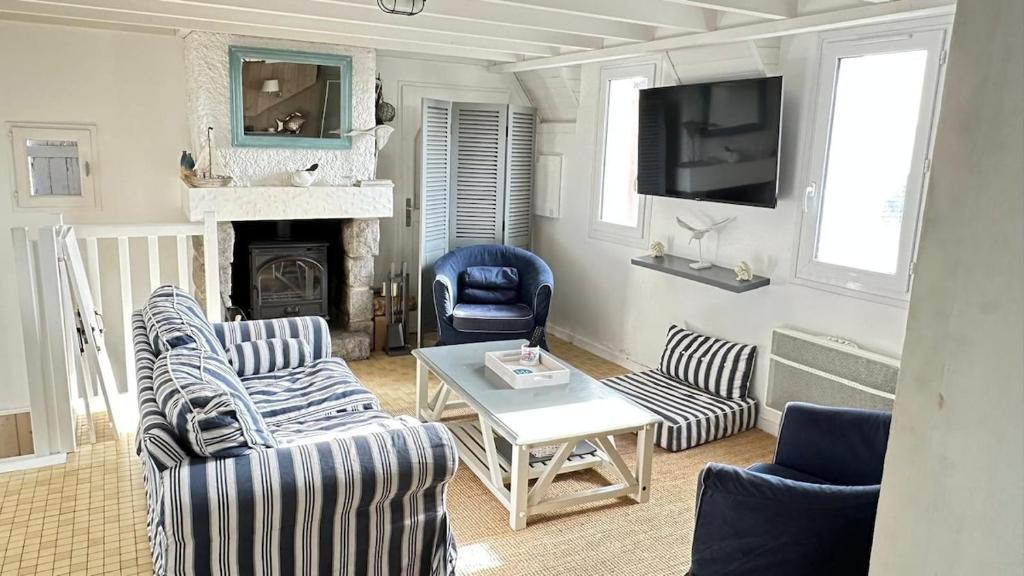 un salon avec deux canapés et une cheminée dans l'établissement Maison des dunes - Proche mer, à Barneville-Carteret