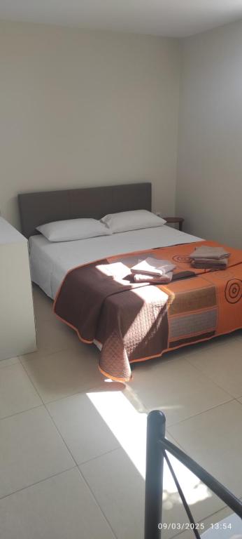 a bedroom with a large bed with a brown blanket at Αegean Εyes 1 in Tinos Town