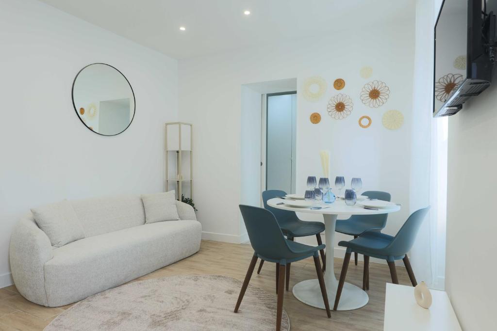 un salon avec une table, des chaises et un canapé dans l'établissement Flat 1BDR 2P Roland Garros Parc des, à Boulogne-Billancourt