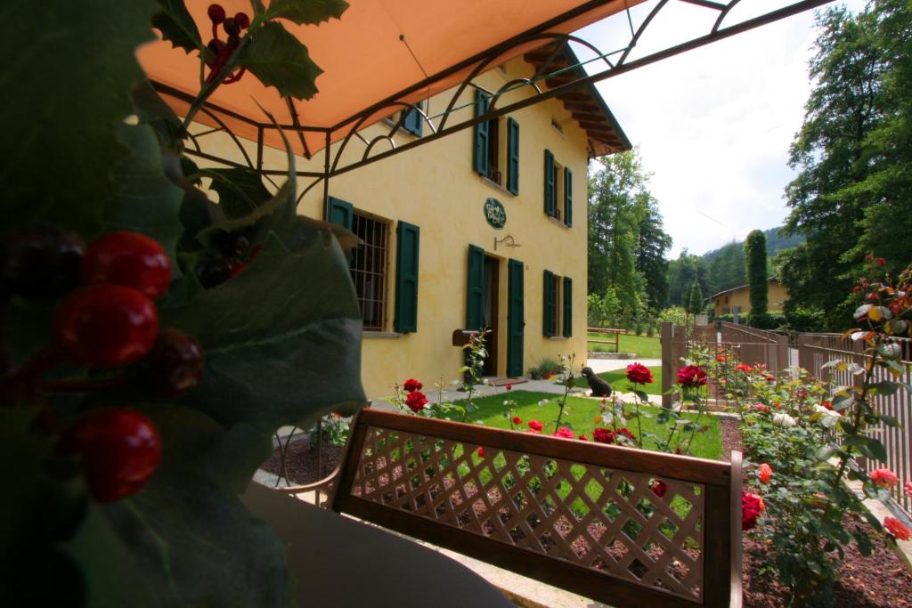 una casa con una valla y un jardín con rosas rojas en B&amp;B La Casa Di Campagna, en Bérgamo