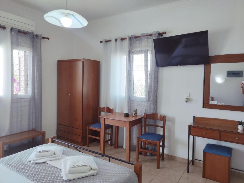a bedroom with a bed and a table and a desk at Vythos in Adamas