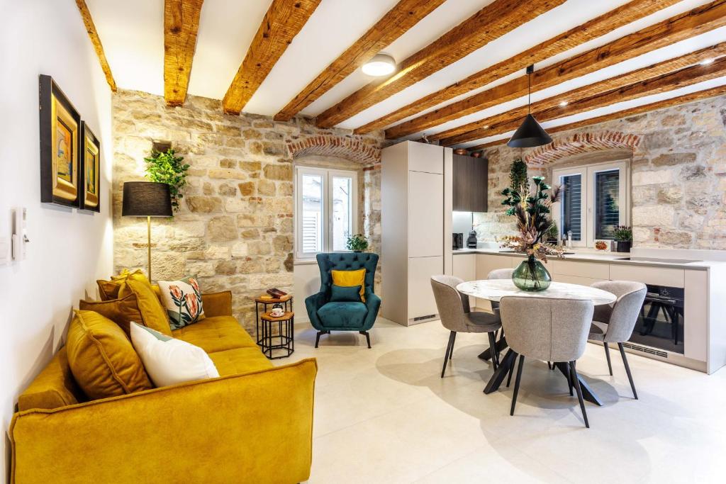 a living room with a yellow couch and a table at Apartment eVaLa in Split