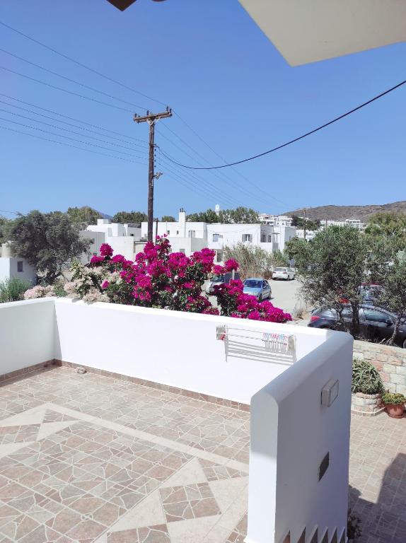 a white fence with a bench on a patio with flowers at Vythos in Adamas