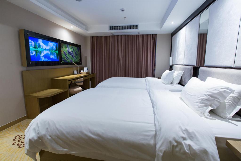 a hotel room with a large white bed and a tv at Lavande Hotel Foshan Shunde Ronggui in Shunde
