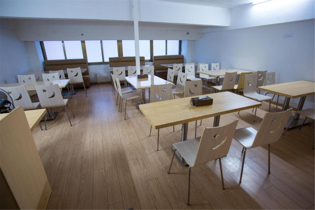 an empty room with tables and chairs in a classroom at Lavande Hotel Foshan Shunde Ronggui in Shunde