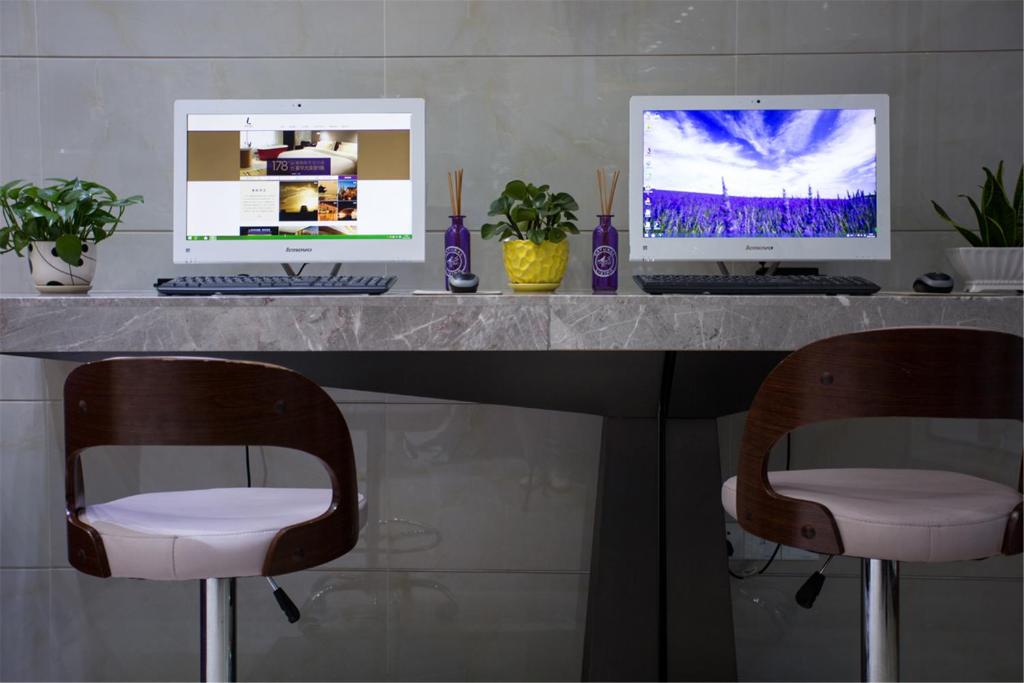 a desk with two computers on top of it at Lavande Hotel Foshan Shunde Ronggui in Shunde