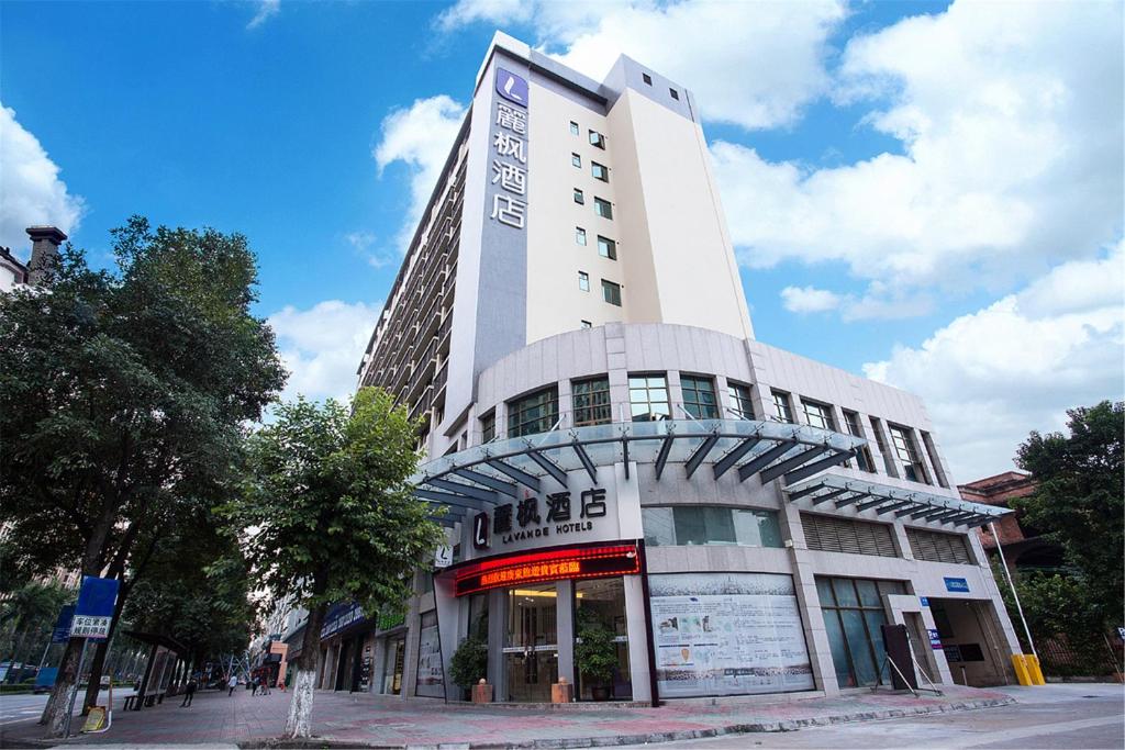 een hoog wit gebouw op de hoek van een straat bij Lavande Hotel Foshan Shunde Ronggui in Shunde