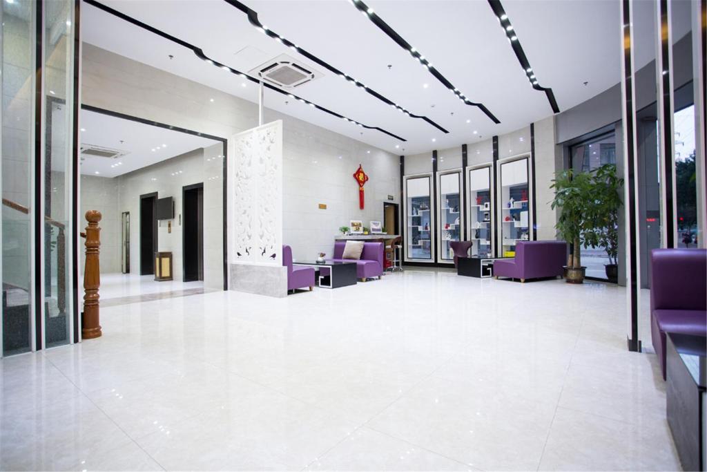 an empty lobby with purple chairs and windows at Lavande Hotel Foshan Shunde Ronggui in Shunde
