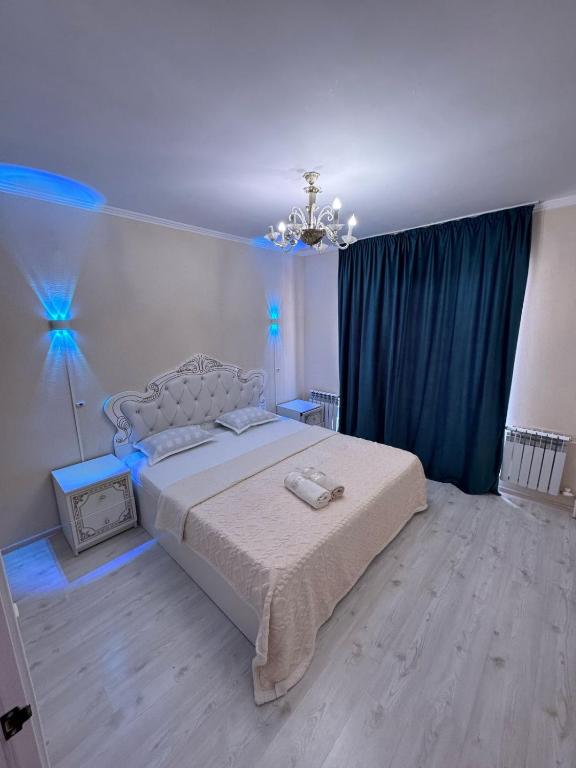 una camera da letto con un grande letto con luci blu di Квартира в аренду береке a Tridtsatʼ Let Kazakhstana