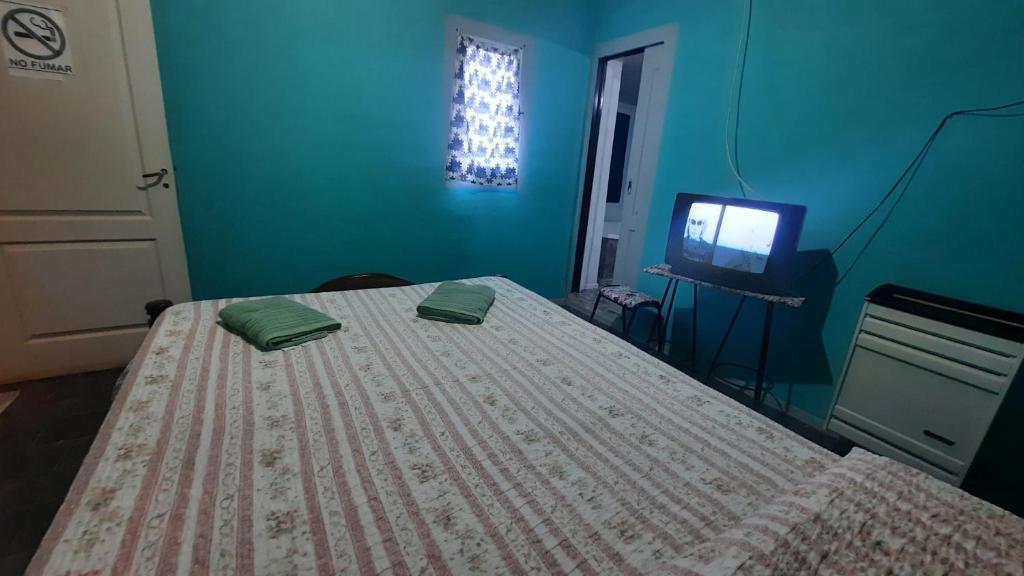 una camera da letto blu con un letto e una televisione di Moni Moni 1 a Río Gallegos