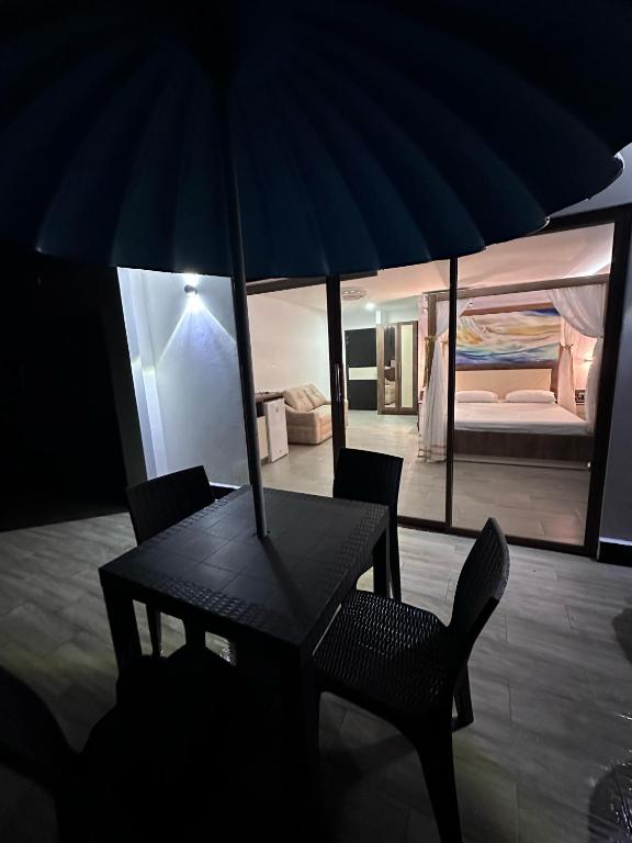 a table and chairs with an umbrella in a room at Hotel Playa Dubai Golden Suite in Cojimíes