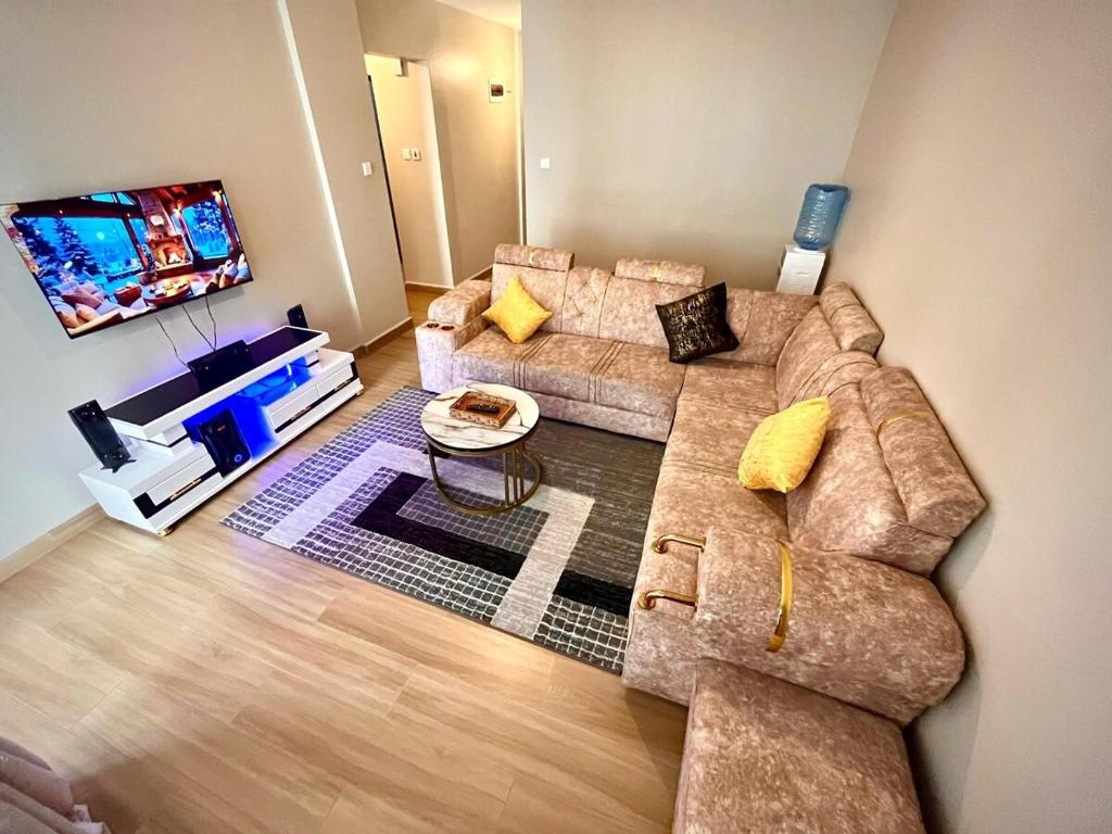 Una sala de estar con dos sofás y un televisor de pantalla plana. en Romish Luxury Homes, en Nairobi