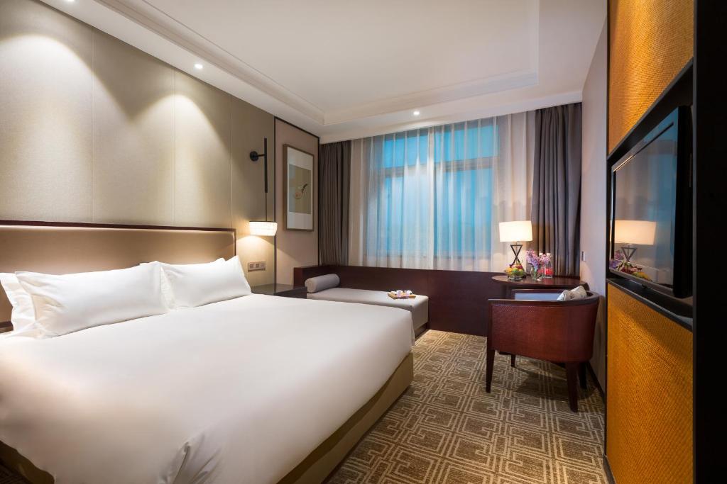 Postel nebo postele na pokoji v ubytování Yiwu Kasion Purey Hotel
