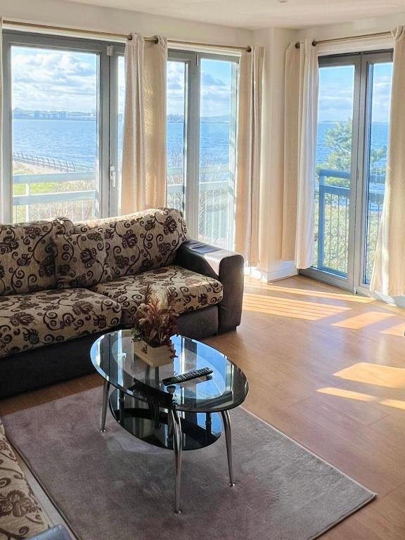 エディンバラにあるBritannia Apartmentsのソファとガラスのテーブルのあるリビングルーム