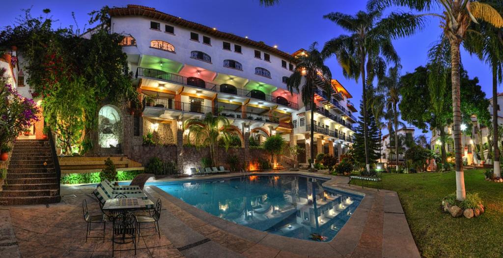 um hotel com piscina em frente a um edifício em Hotel Posada San Javier em Taxco de Alarcón