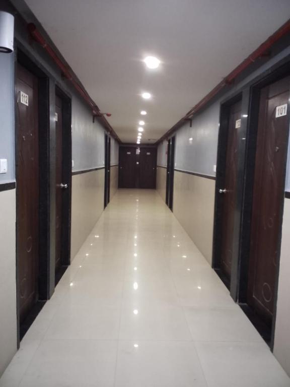 a long hallway with doors and a corridorngthngthngthngthngth at Infinity Rooms D-Mart in Surat