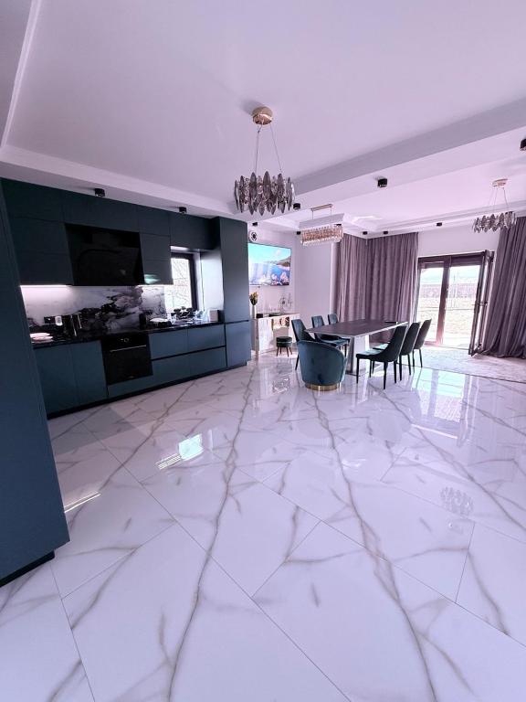 a large white room with a dining room and a kitchen at VILA Neptun Jacuzi SPA in Săcele