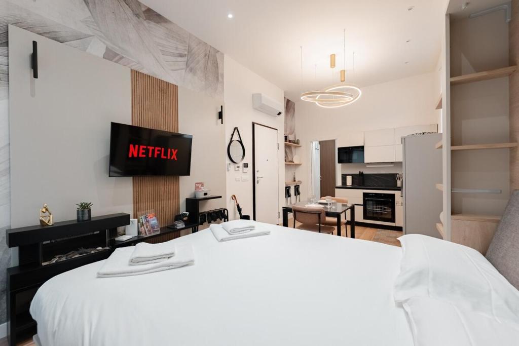 a bedroom with a white bed and a kitchen at Casa Giusy Esclusiva Suite Molinette Torino in Turin