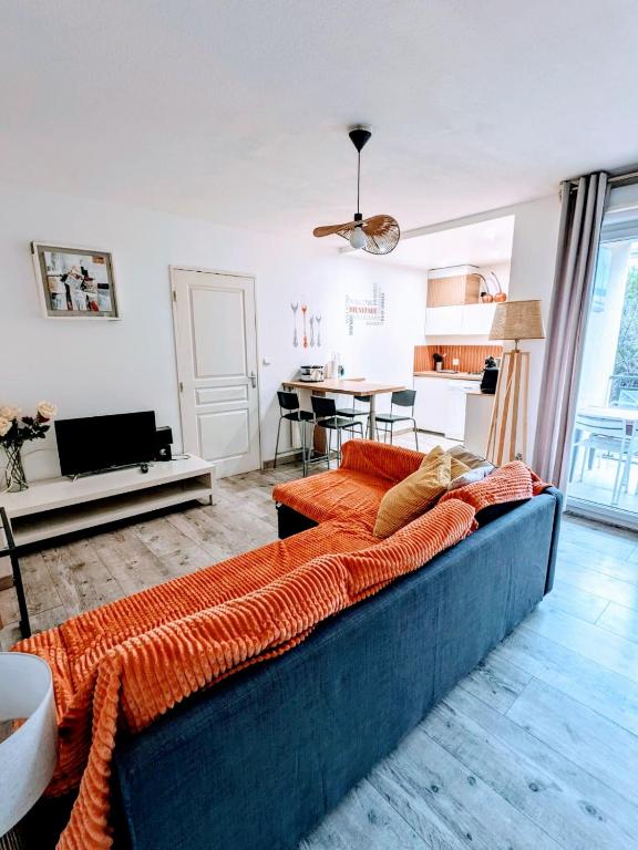 un salon avec un canapé bleu et une cuisine dans l'établissement F2 garage box WiFi terasse clim Gare Fac Eco Richter, à Montpellier