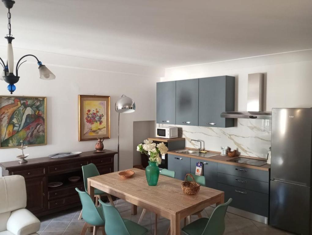 a kitchen with a wooden table and green chairs at MARCELLA Appartamento Full-optional in Centro Storico in Tropea