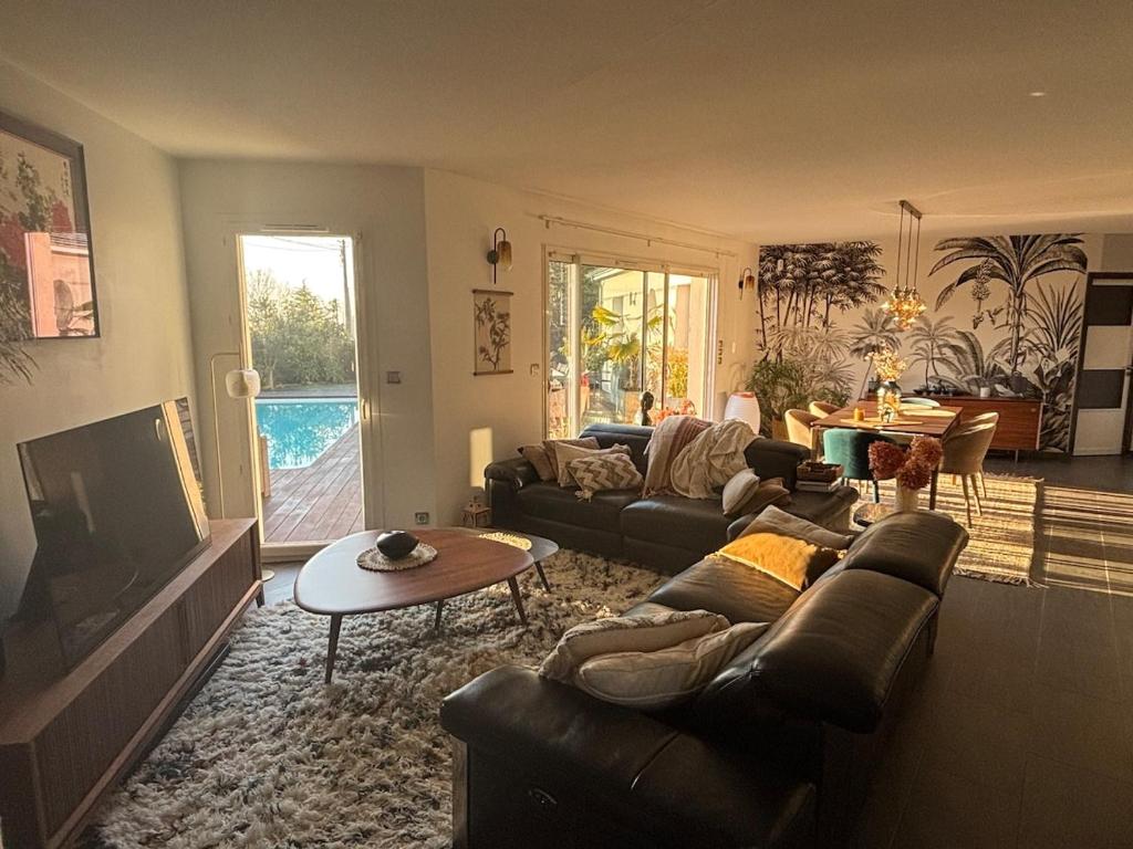 - un salon avec des canapés, une télévision et une table dans l'établissement Luxury spa house - healing, à Tarnès