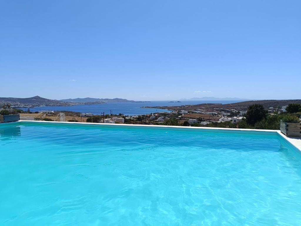 ein großer Swimmingpool mit Blick auf das Wasser in der Unterkunft White Blue Houses & Apartments Paros in Parikia
