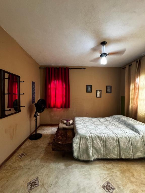 a bedroom with a bed and a red window at Casa com vista in Lençóis