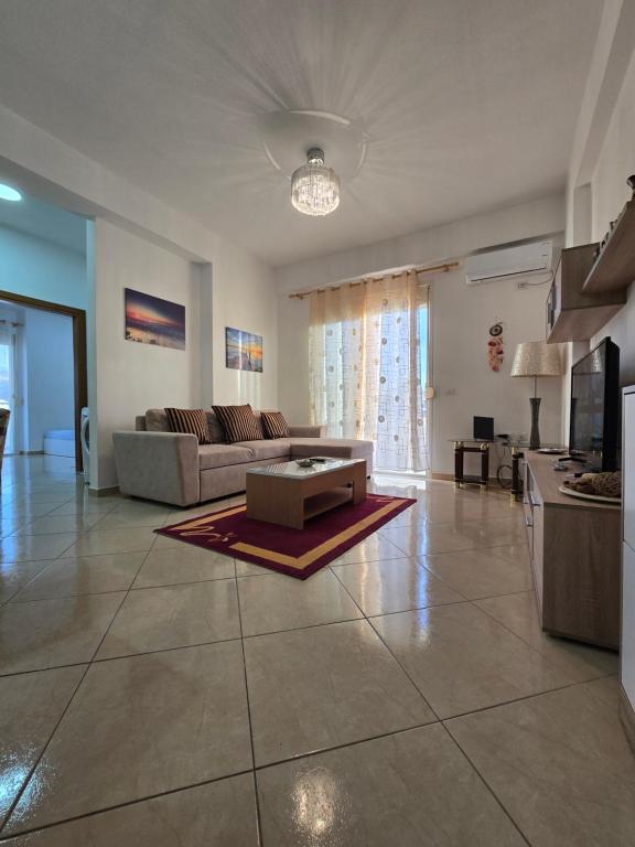 a living room with a couch and a table at Modern , quiet , family friendly & fully furnished apartment in Vlorë