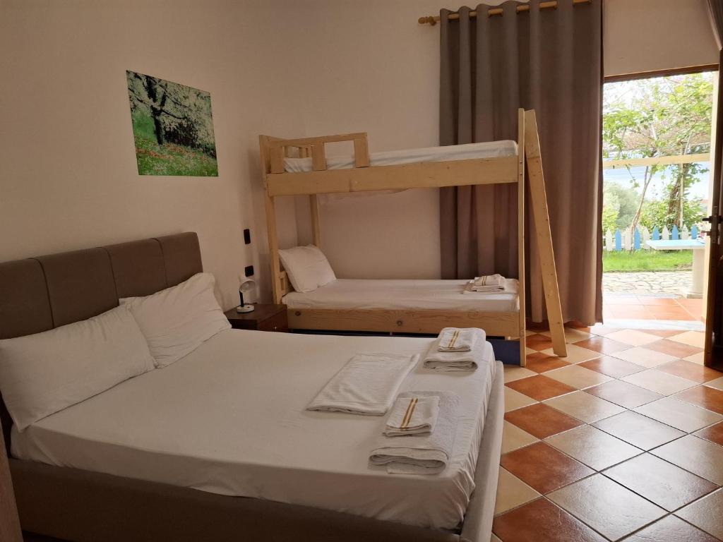 a bedroom with a bed and bunk beds in it at Hotel Sirena in Vlorë