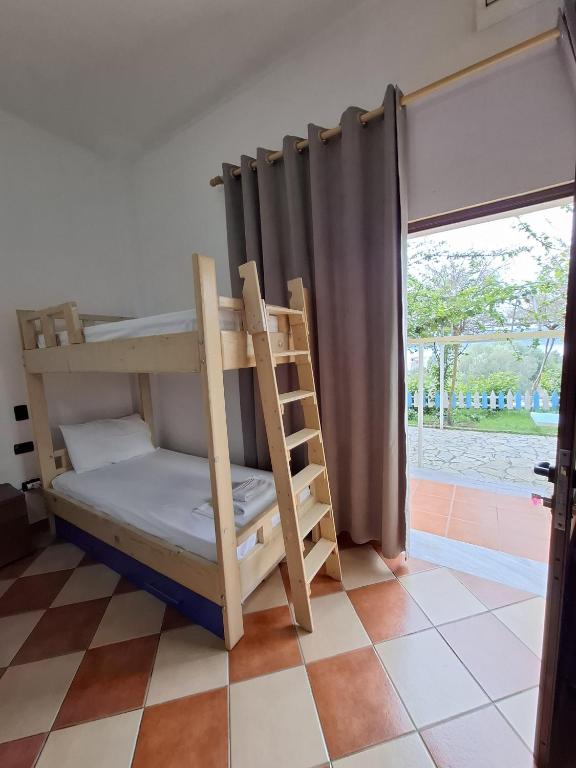 a bunk bed in a room with a window at Hotel Sirena in Vlorë