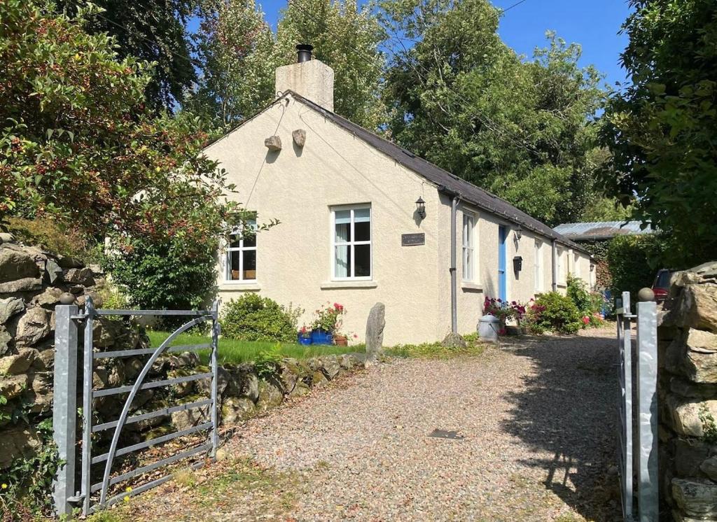 a white house with a fence in front of it at Curragh-Ard Cottage in Newcastle