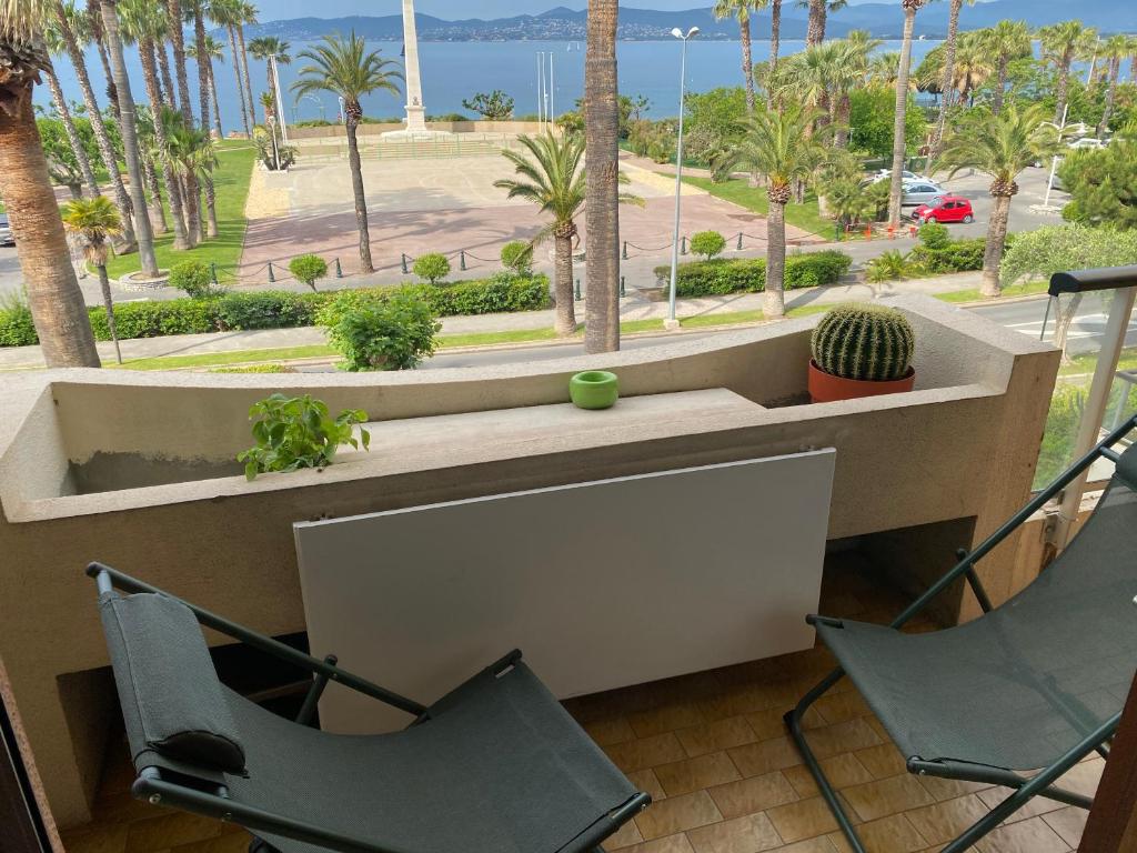 - un balcon avec deux chaises et une table avec un cactus dans l'établissement Charmant studio en front de mer avec balcon, à Saint-Raphaël