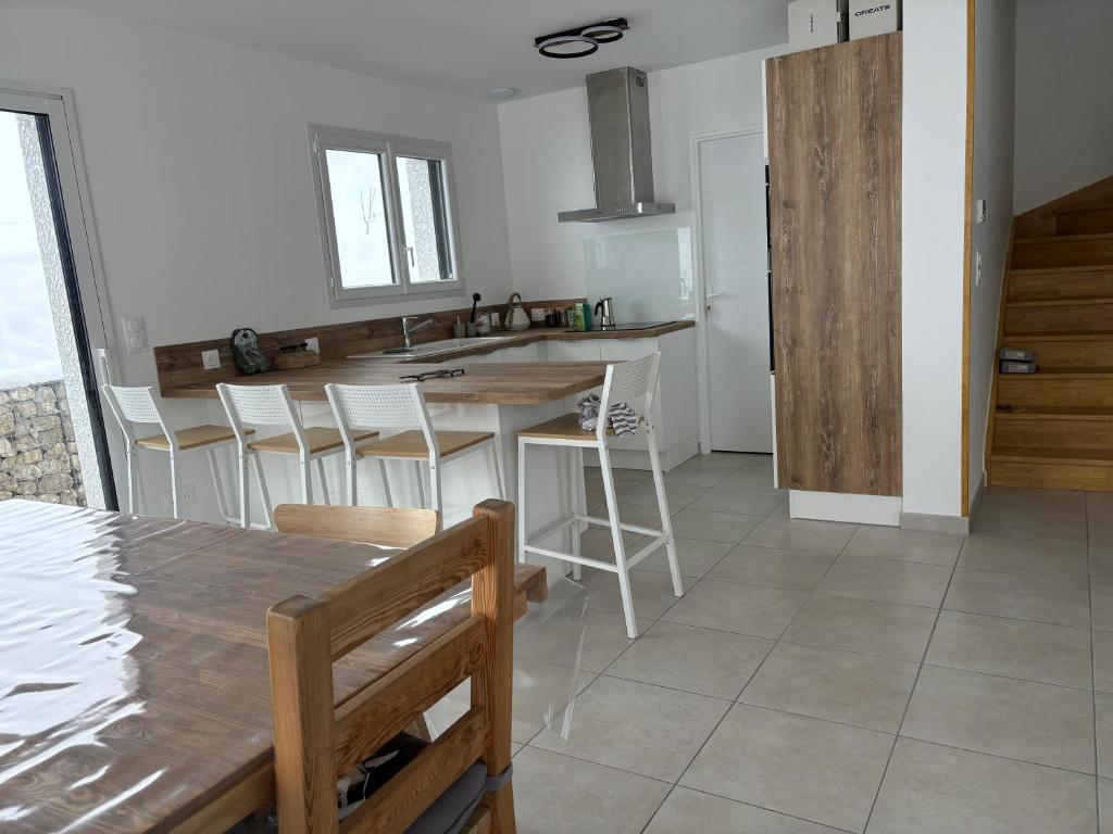 une cuisine avec une table, des chaises et un comptoir dans l'établissement Jolie maison à la montagne, à Les Déserts