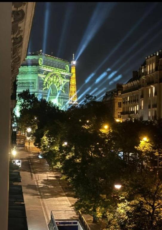 un bâtiment avec une tour éclairée la nuit dans l'établissement Cozy Room Nearby Champs Elysées 12, à Paris