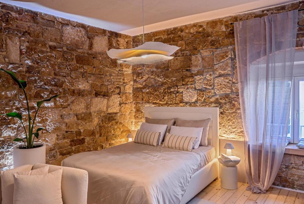 a bedroom with a bed and a brick wall at Studio Palace Gates in Split
