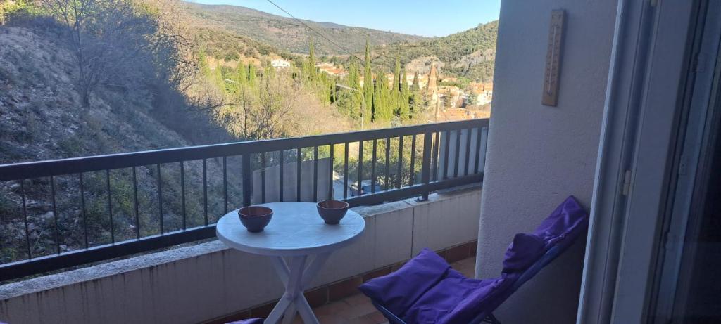 - un balcon avec une table et deux tasses dans l'établissement 50m des cures studio Phannie wifi parking grand balcon vue dégagée, à Amélie-les-Bains-Palalda