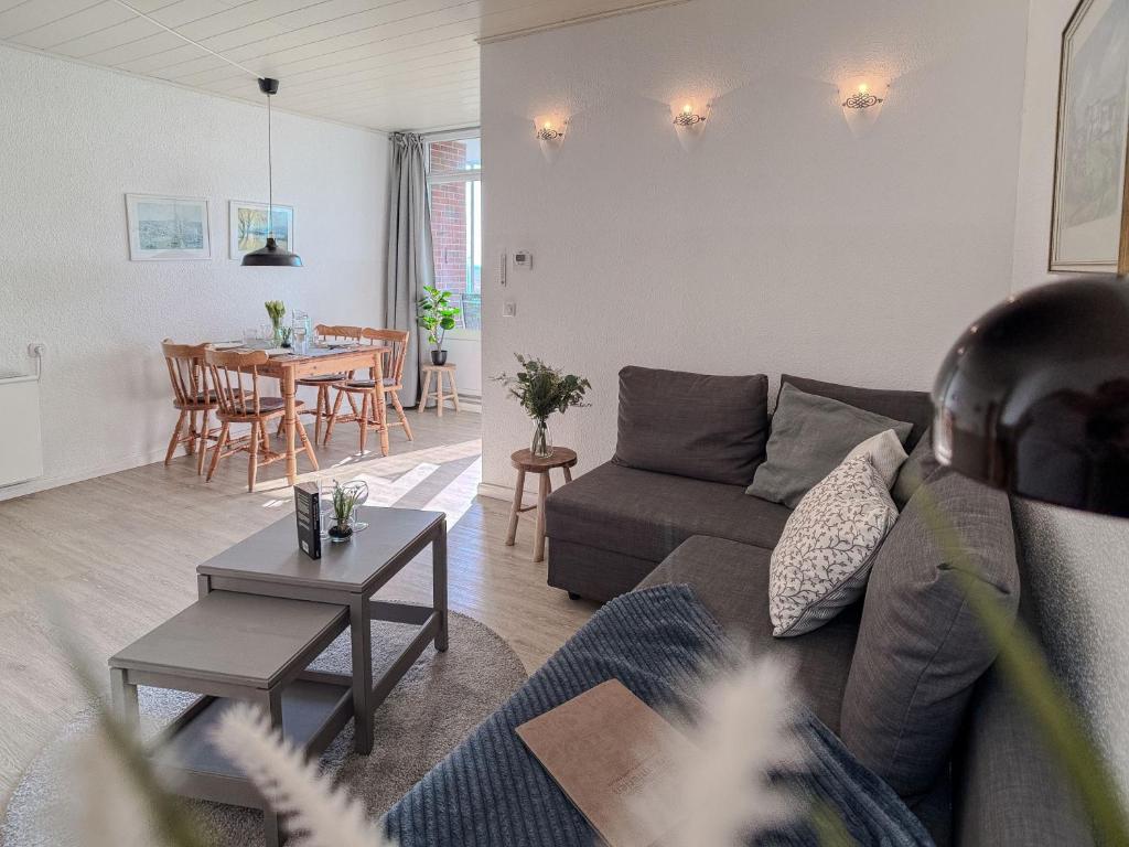 a living room with a couch and a table at FeWo Sielblick mit Balkon - Horumersiel in Horumersiel
