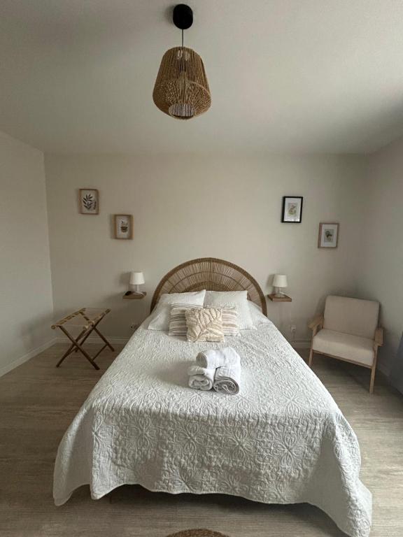 Un dormitorio con una cama blanca con dos toallas encima. en Hôtel La Coursive, en Saint-Pierre-dʼOléron