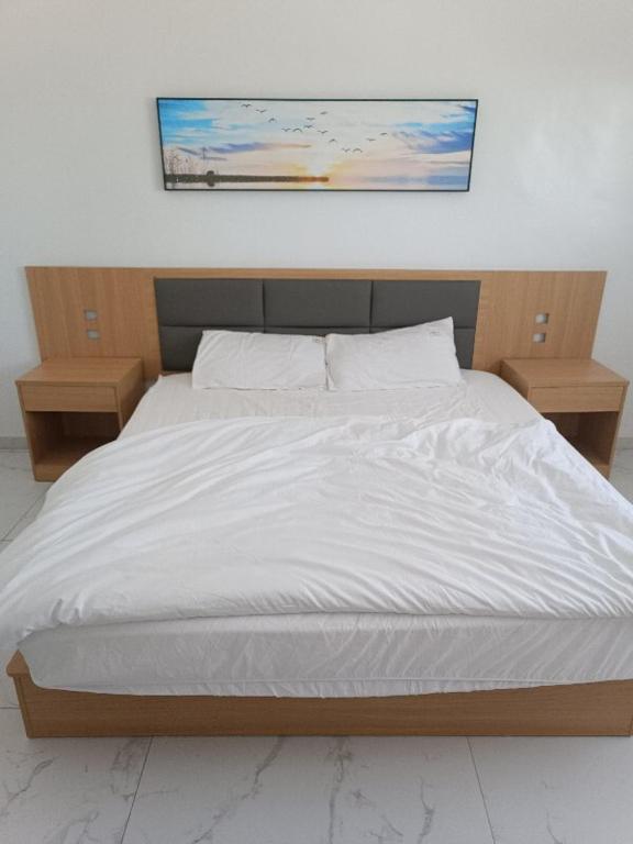 una camera da letto con un letto bianco con due comodini di 中非国际 a Nouadhibou Airport