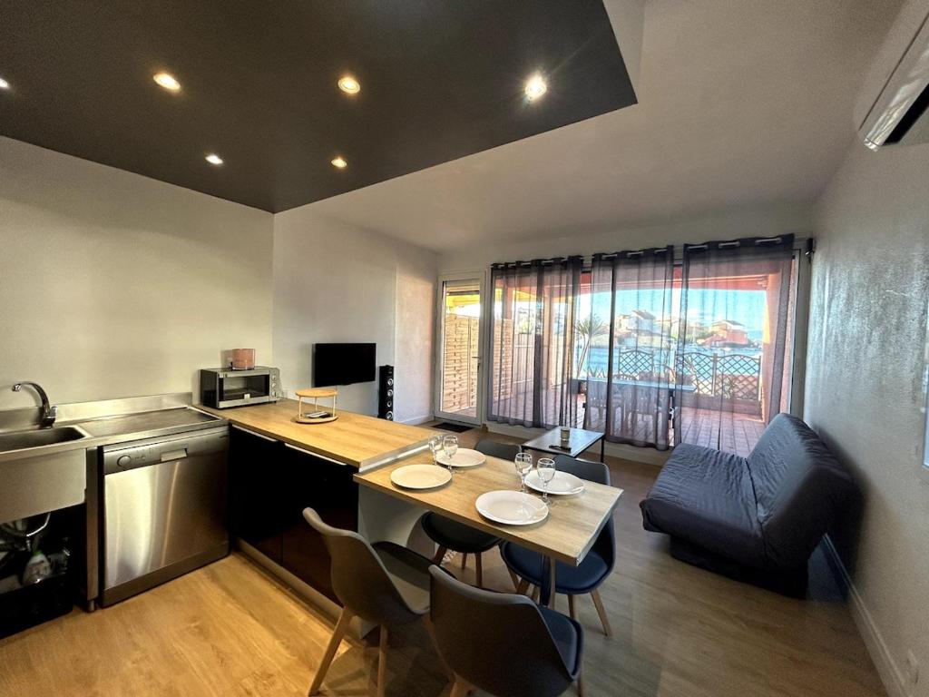 une cuisine avec une table et des chaises dans une pièce dans l'établissement appartement climatisé au bord du lac marin, au Barcarès