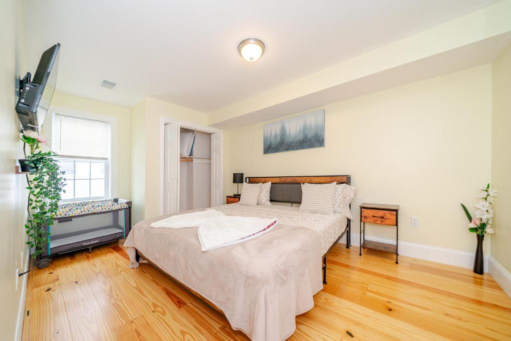 a bedroom with a large bed and a television at Bright 3BR Quincy Townhouse w Laundry, Bathtub & Near Red Line 41 in Quincy