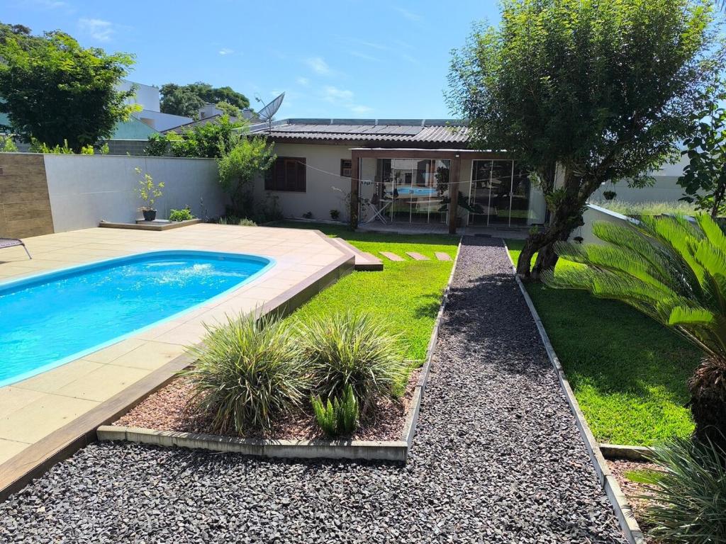 a yard with a swimming pool and a house at Casa da Piscina in Rolante