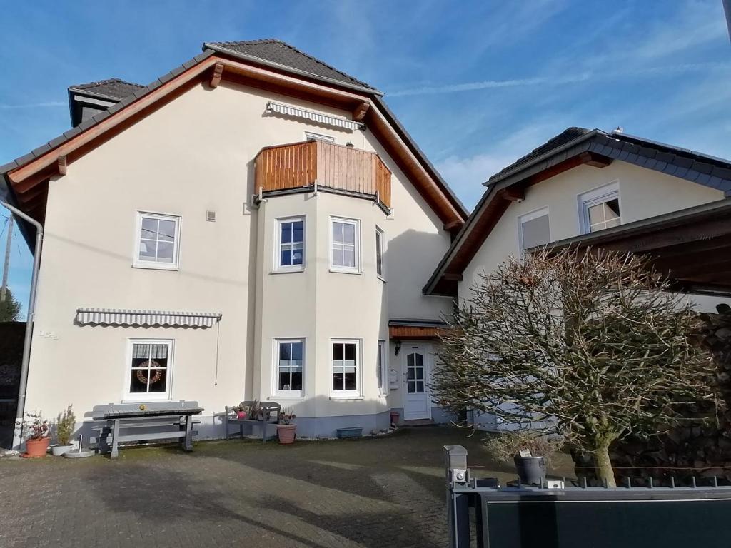 a large white house with a bench in front of it at Ferienwohnung Schmitz in Lindlar