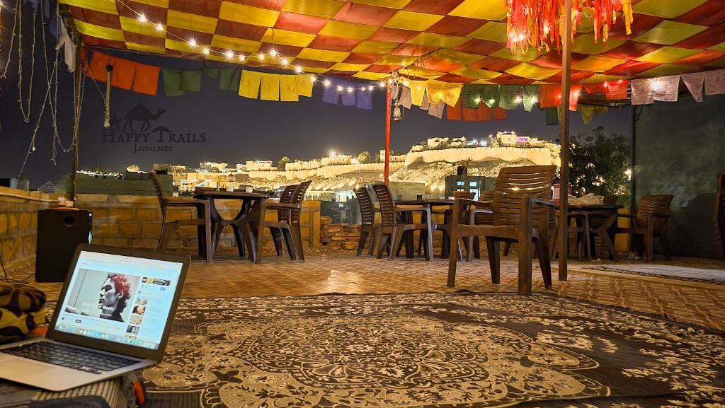 a laptop computer sitting on a table in a restaurant at Happy Trails Jaisalmer in Jaisalmer