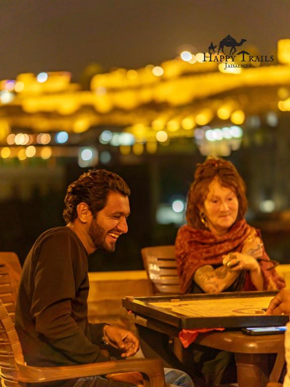 a man and a woman sitting at a table at Happy Trails Jaisalmer in Jaisalmer