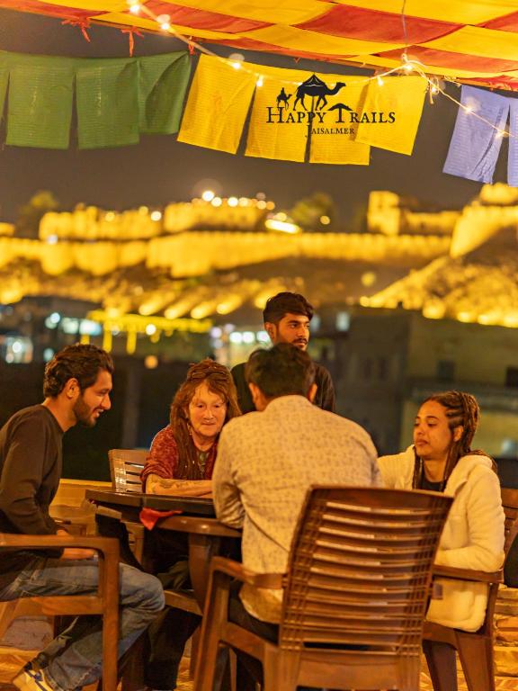 a group of people sitting at a table in a restaurant at Happy Trails Jaisalmer in Jaisalmer