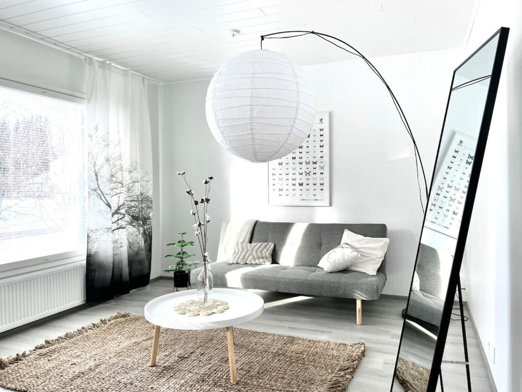 a living room with a couch and a table at Valoisa uusi kaksio keskellä Suomea in Haapavesi