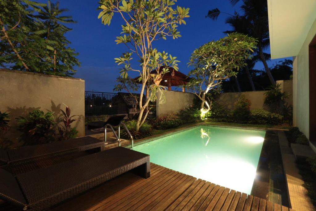 una piscina en un patio trasero por la noche en Duana Sari by Mahaputra en Ubud